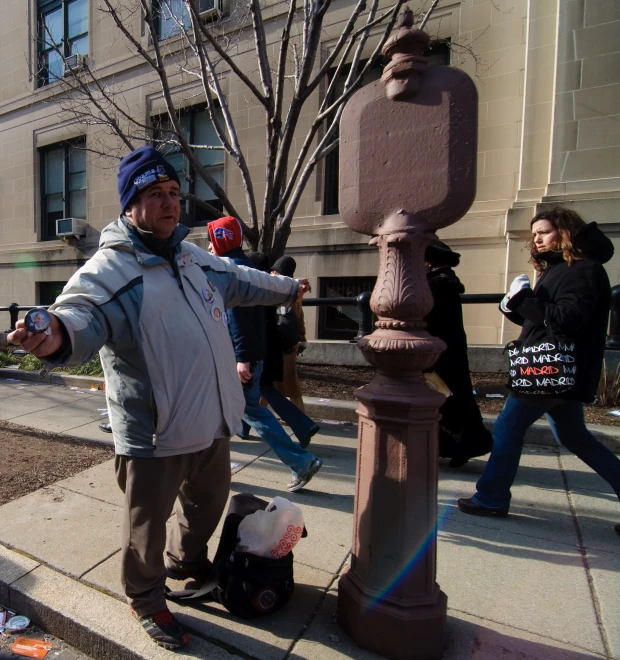 a man standing next to a lamppost with two stuffed animals