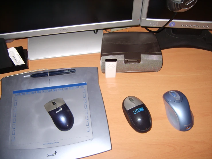there are several computer mouses and a tablet on the desk