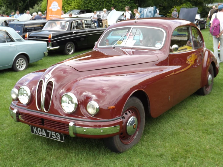 a car sits parked on some grass in a show