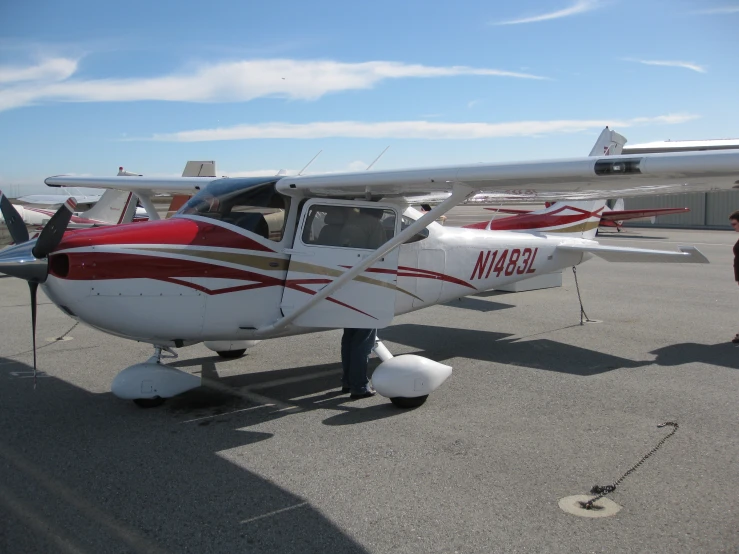 a small red and white airplane on the runway