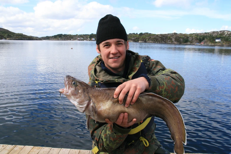 a man holding a fish with another fish on it