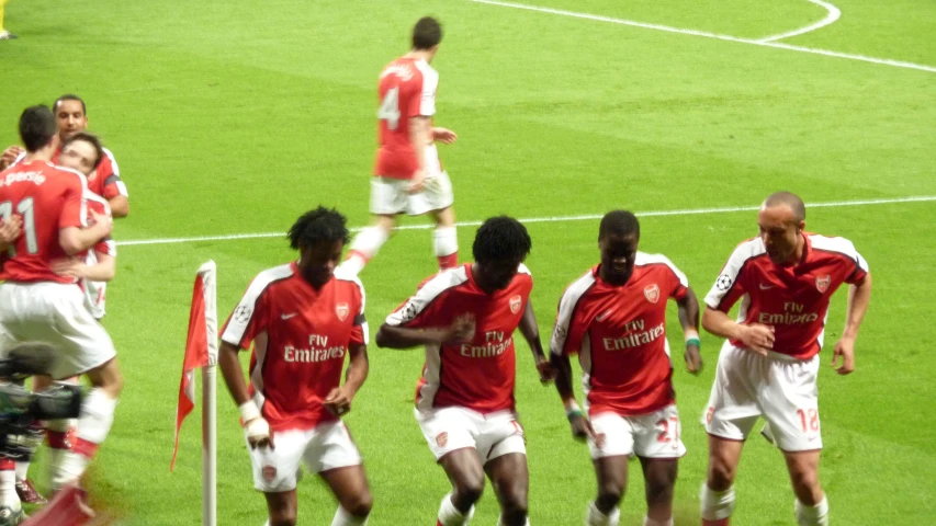 two teams are celeting with each other in front of a referee