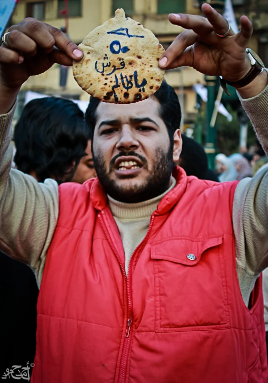 a man holding up a cookie above his head