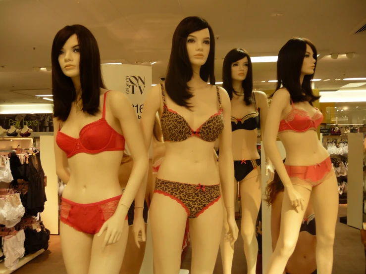 four woman wearing underwear standing in front of the store mannequins