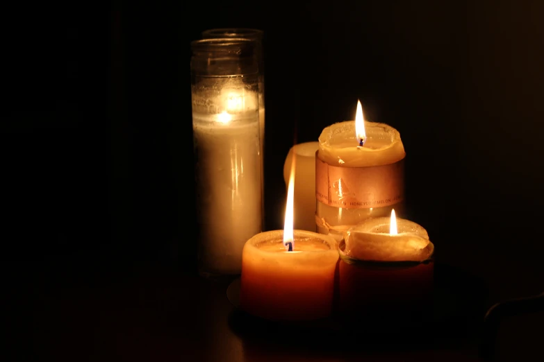 a bunch of small lit candles on a table