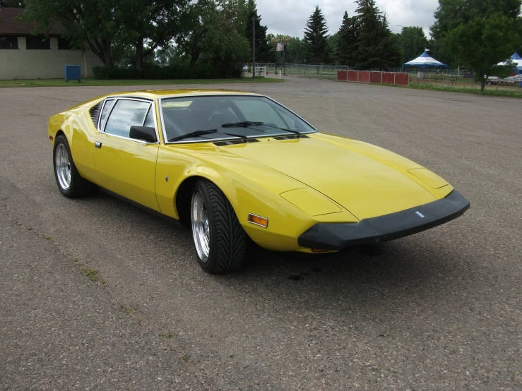 a bright yellow car is parked in a parking lot