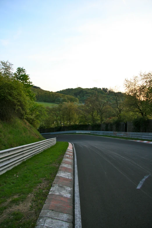 the corner of a road that is surrounded by hills