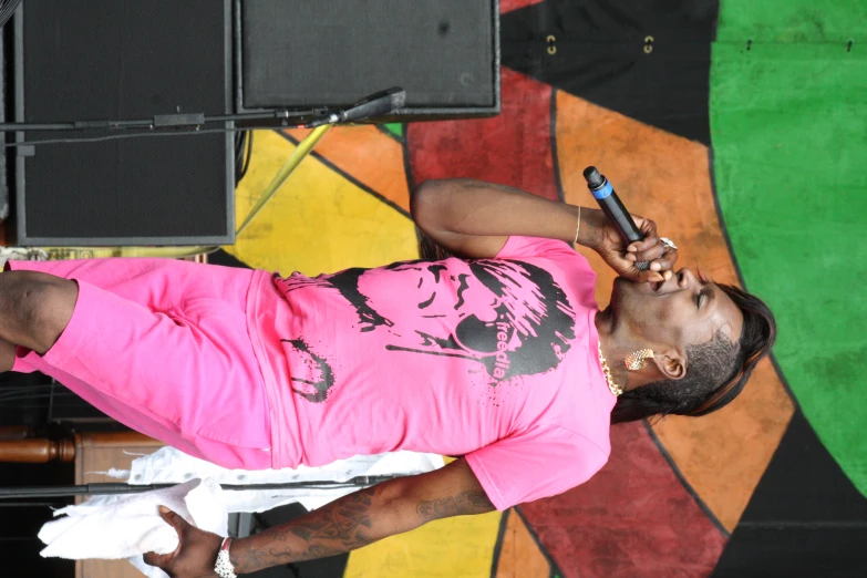 a man in pink is singing into his microphone