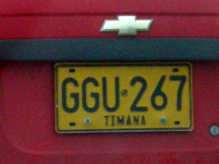 a close up of a license plate on a red vehicle