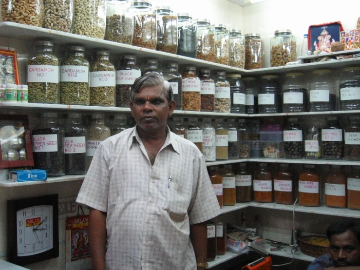 a man is standing in a store surrounded by jars