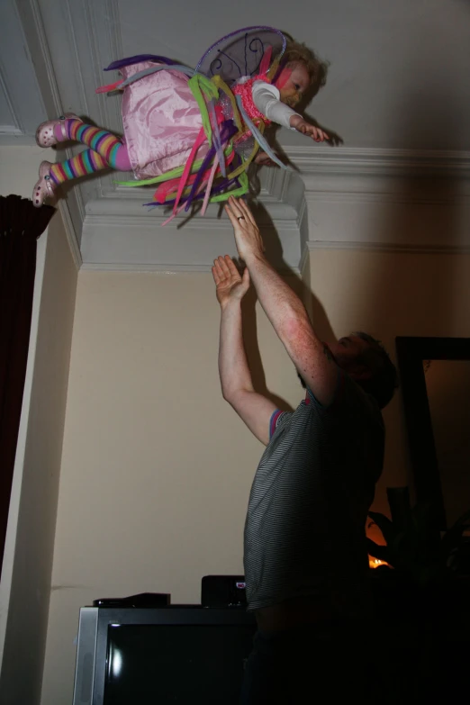 there is a man and baby in the air holding some string