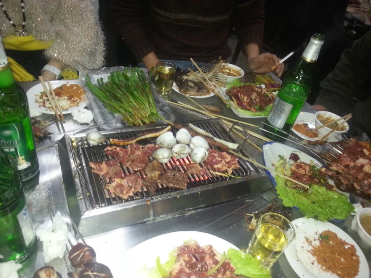 people eating from trays of food next to a table