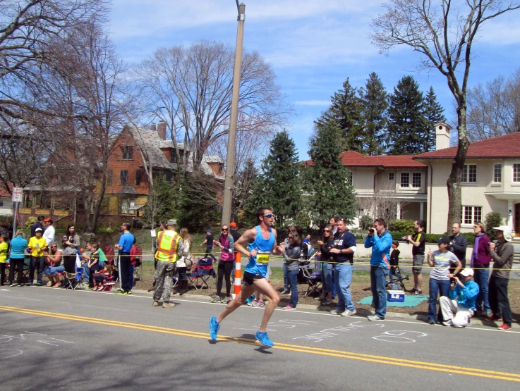 a large group of people watching a person running in a marathon