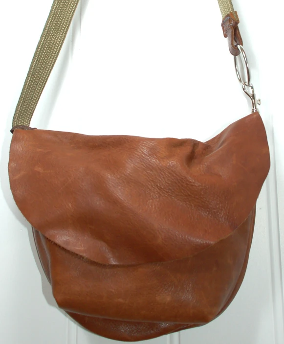 a brown leather handbag hanging on a door