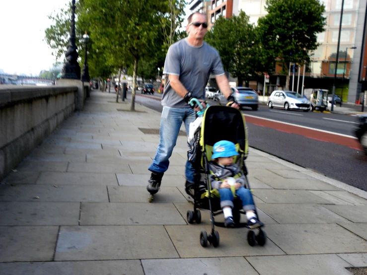 a man hing a stroller and hing a child on it