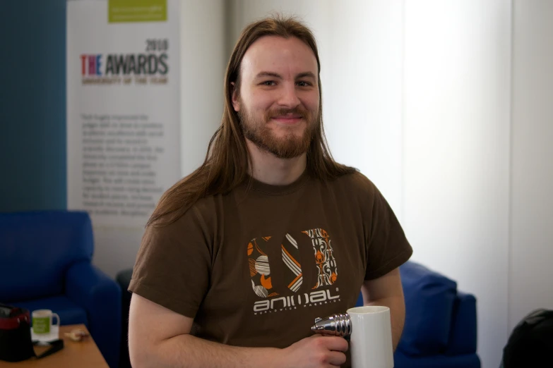 a man is holding up his coffee mug