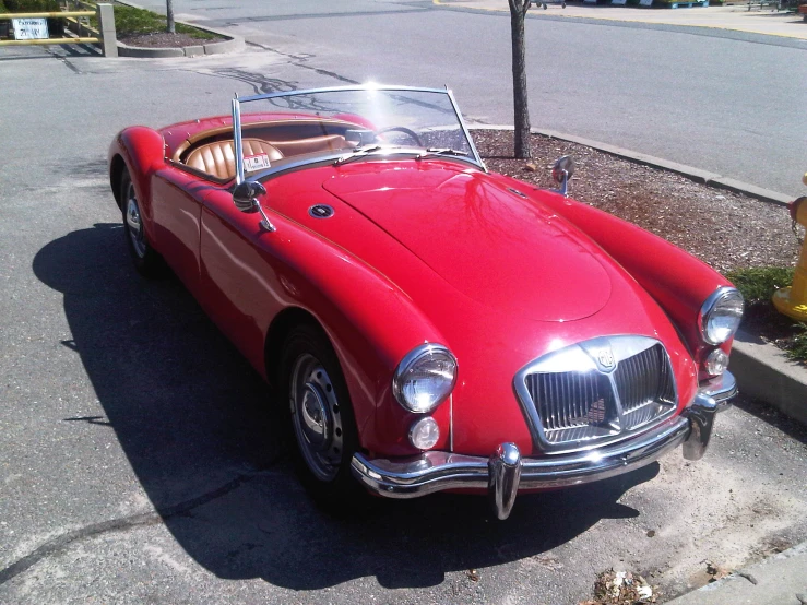 an old style red car parked in a parking lot