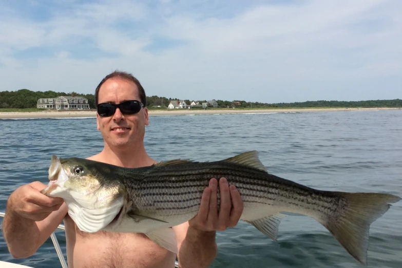 a man sitting in a boat holding a fish