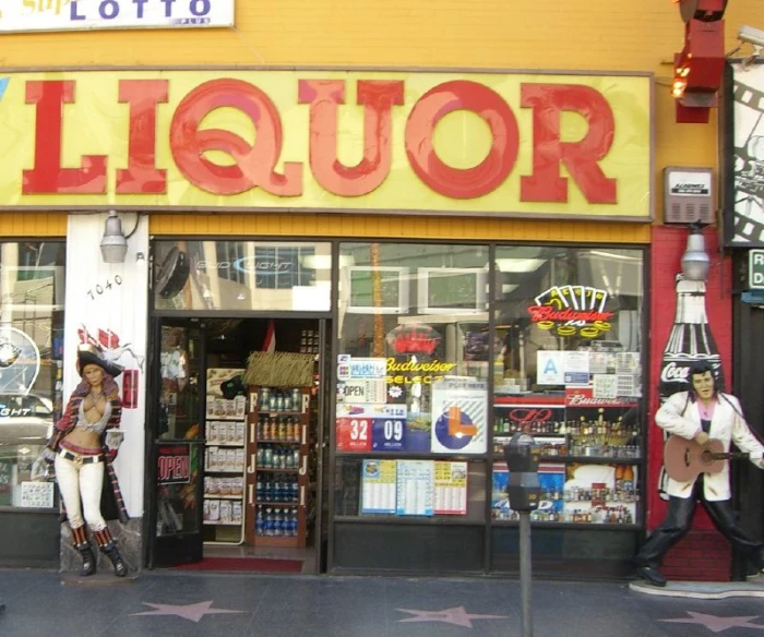 the facade of a liquor store is made out of paper machts and neon letters
