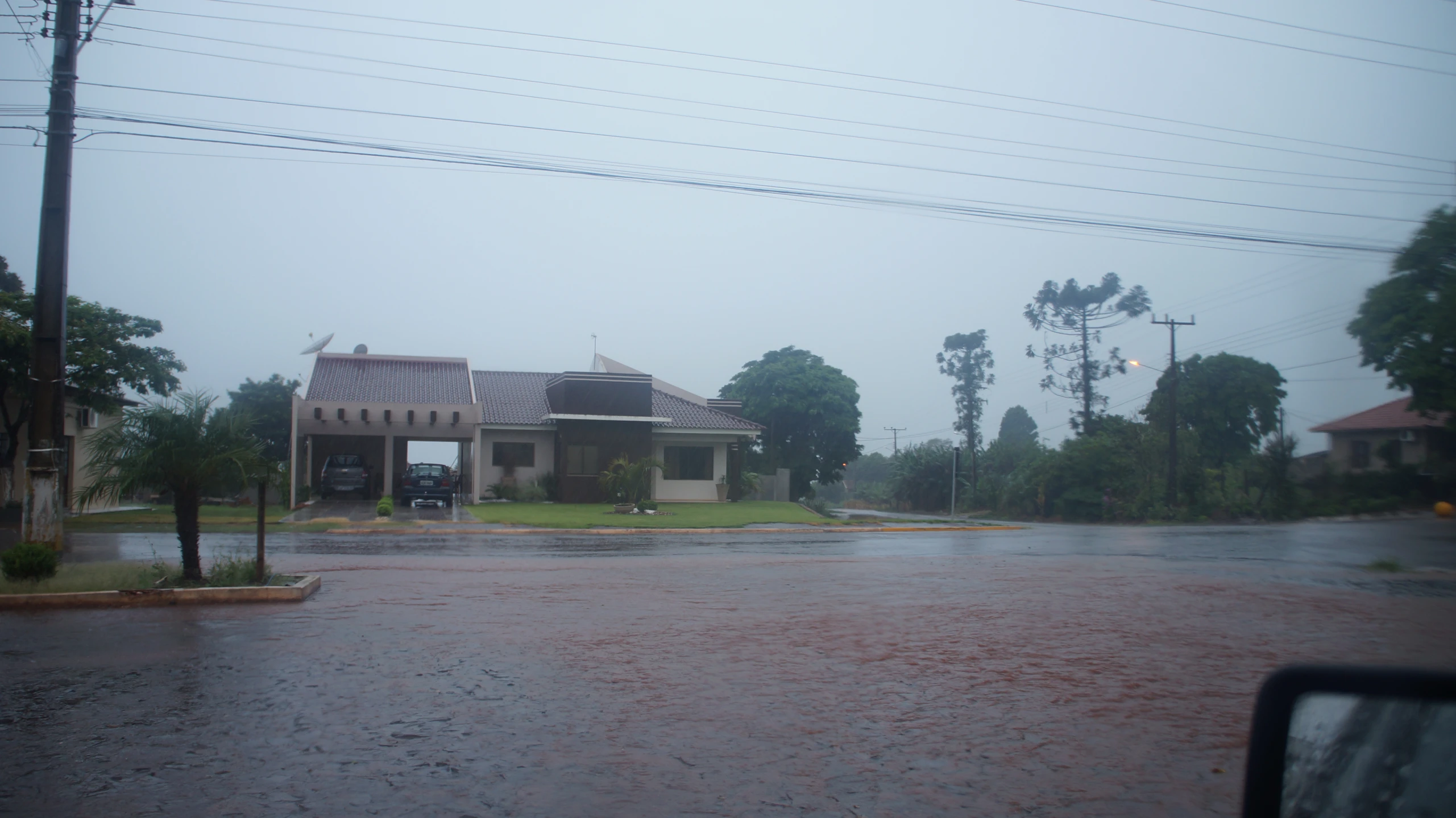 rain is pouring in front of an old house