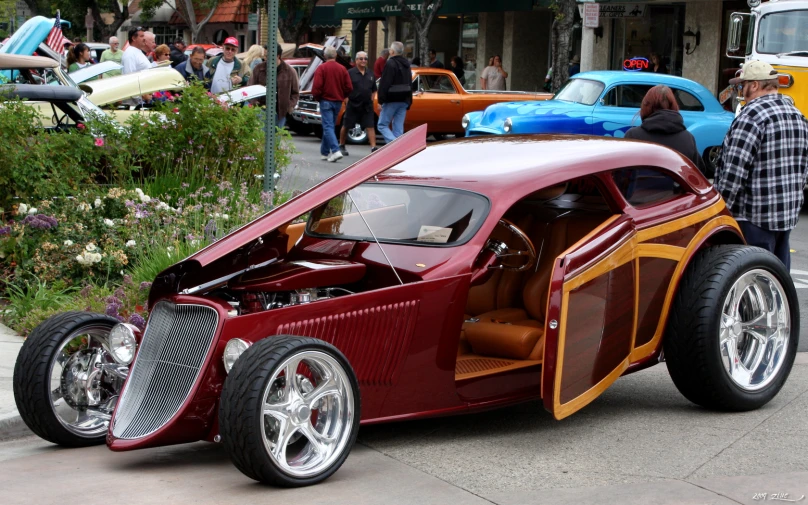 an unusual, brightly painted car is shown parked on the street