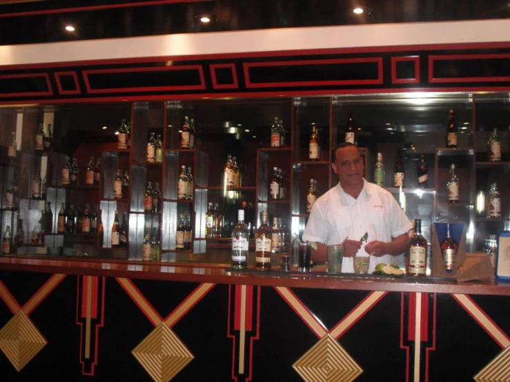 a man sitting at a bar with bottles on a display