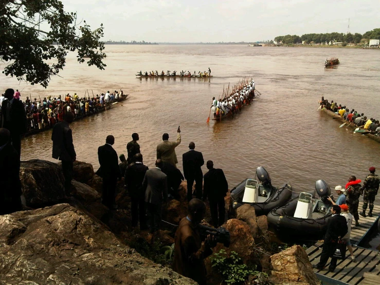 several people watching boats on the water