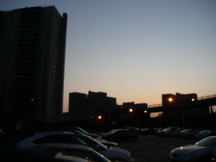 some cars parked in a parking lot in the evening