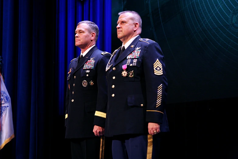 two men standing next to each other in uniforms