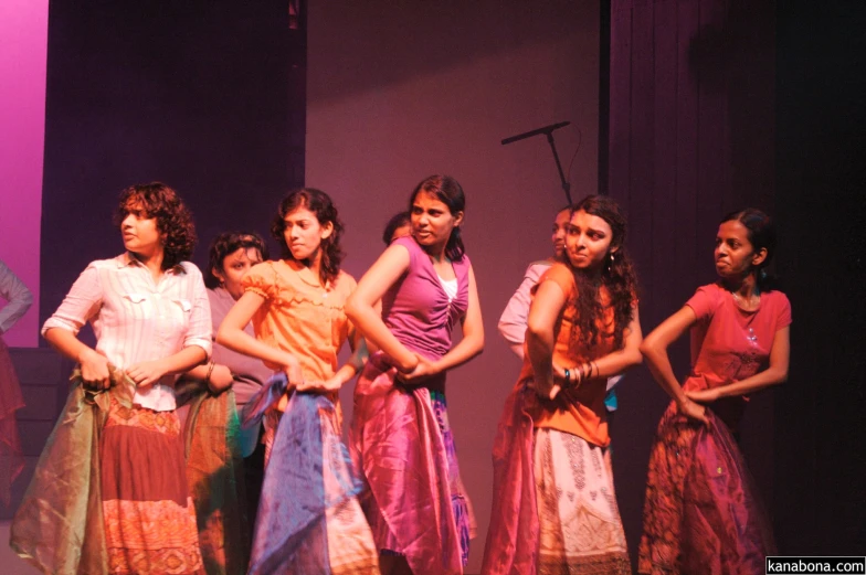 several girls on stage with one holding the leg of another woman