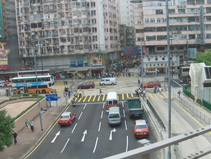 city intersection full of cars and buses on both sides