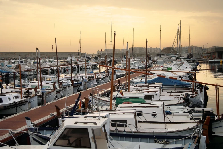 some boats are parked in the water with a sunset behind them