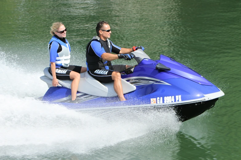 two people riding on a jet ski while in the water