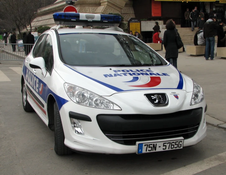 a small white car with blue and red writing on the side