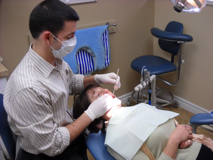 a man wearing a mask is laying down on a dentist chair
