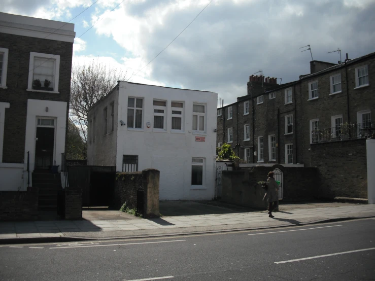 a person crossing a street in front of a row of houses