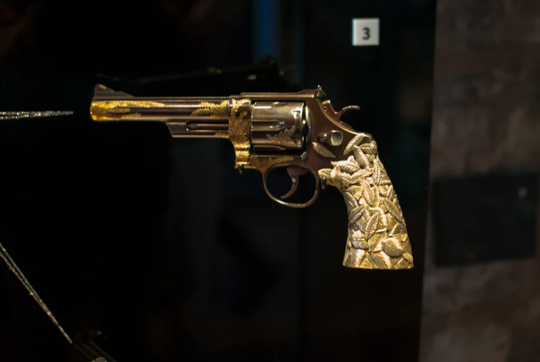 an old pistol is seen as it holds out gold in an image