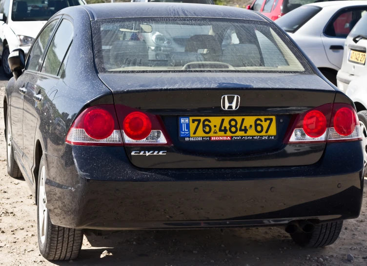 back end of a car parked on a lot of other cars