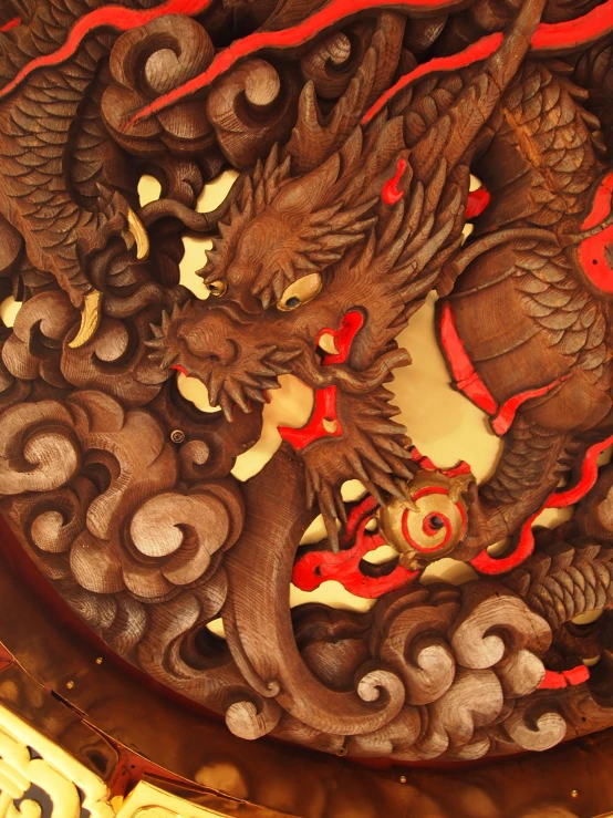 a clock with an ornate carving of two dragon heads