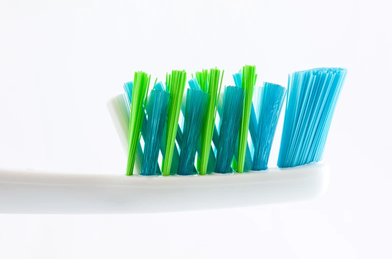 a white and green toothbrush stand next to each other