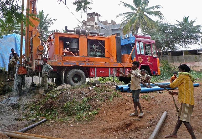 a couple of men hing a pipe into a truck