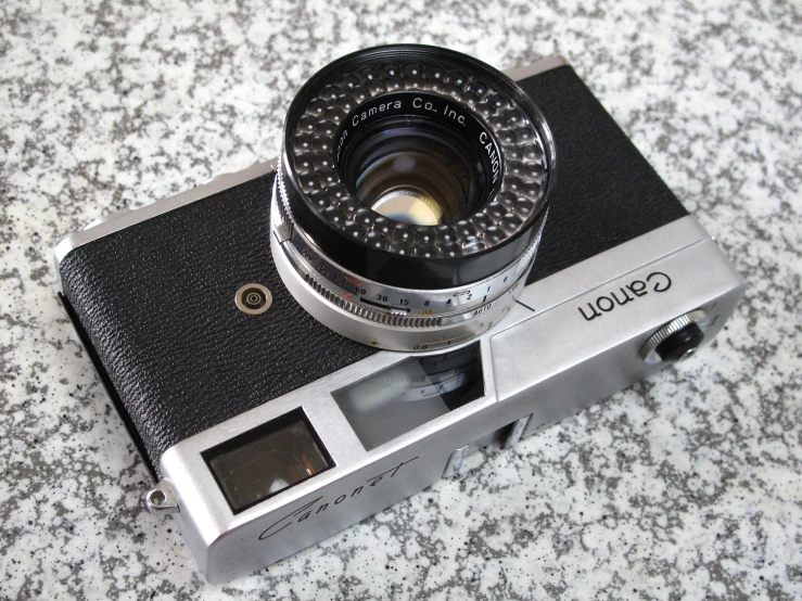 an old fashioned camera with an lens sitting on the counter