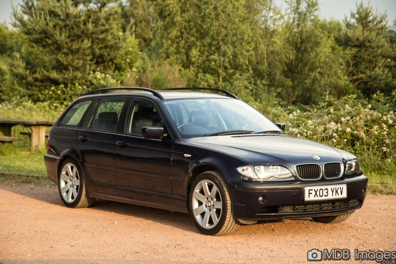 a black car parked by a wooded area