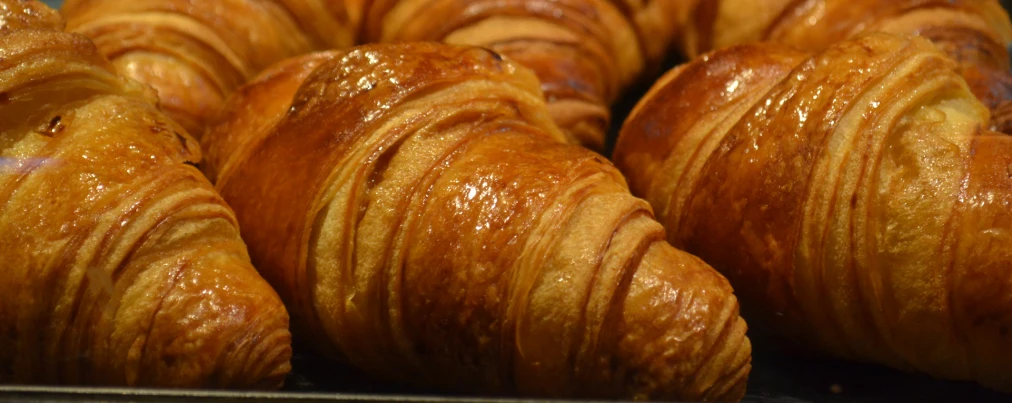 some very pretty looking big pretty croissants in a pan