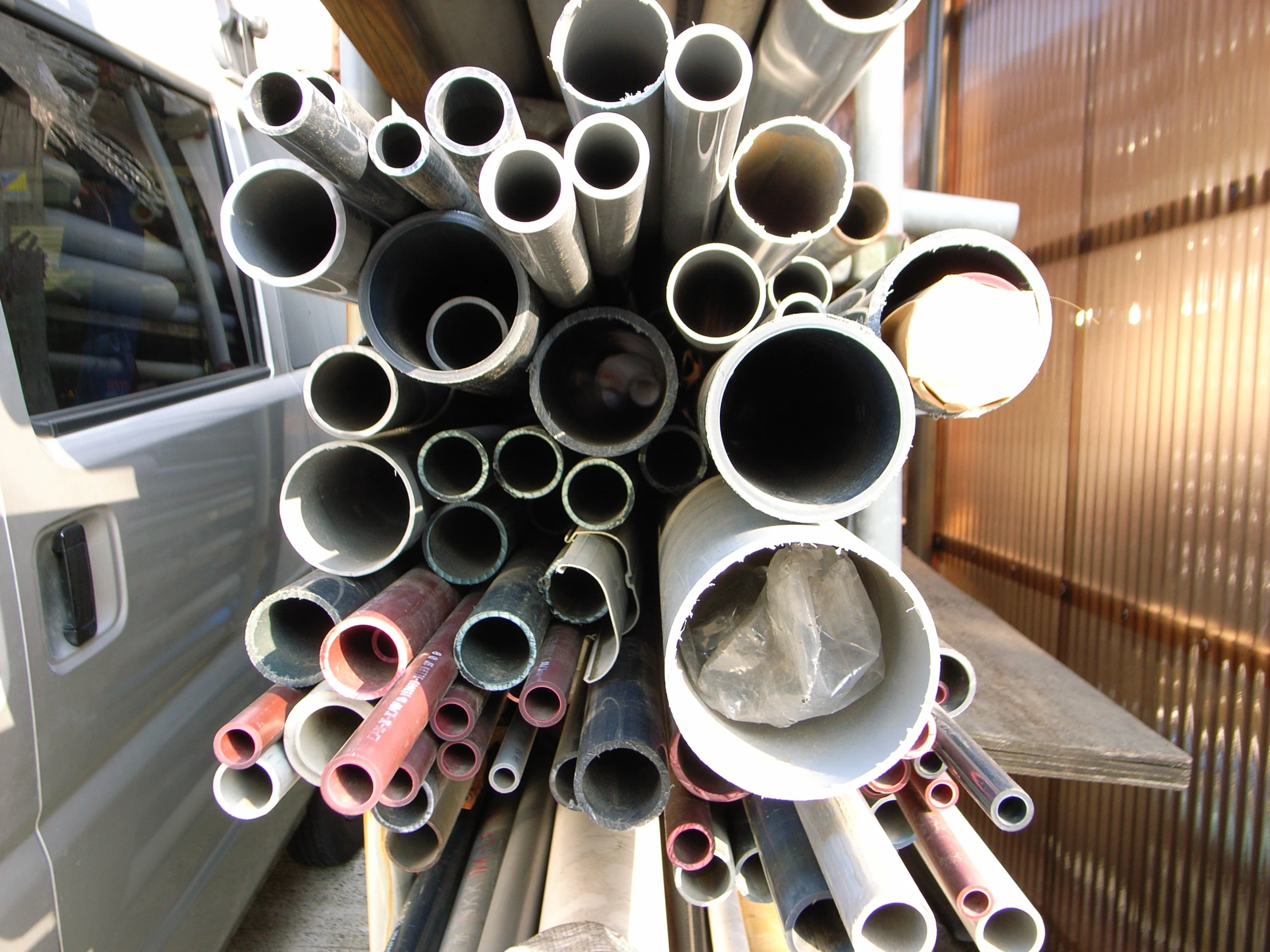 there are many pipes piled together near a truck