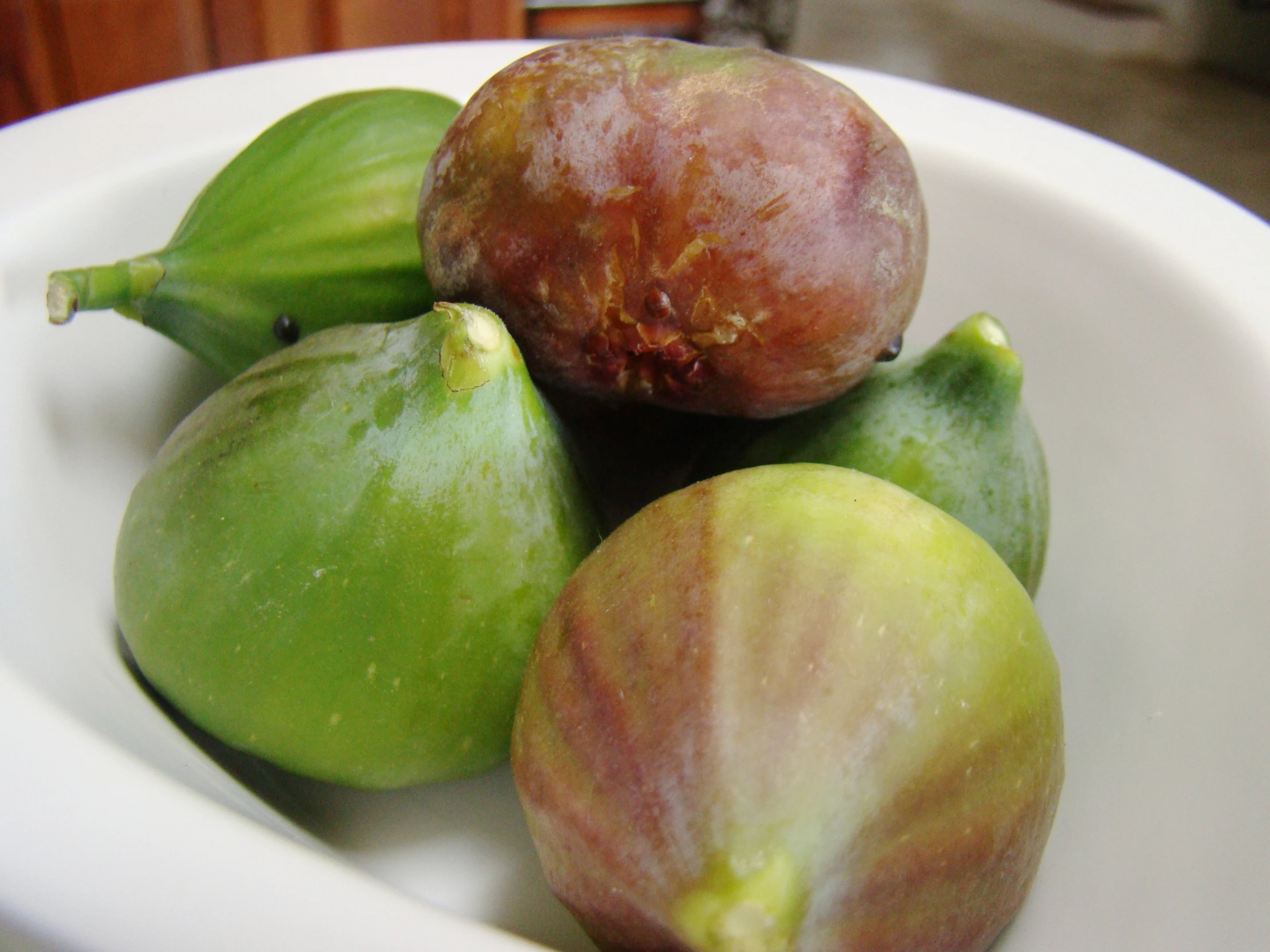 a bowl with a fig and other fruits