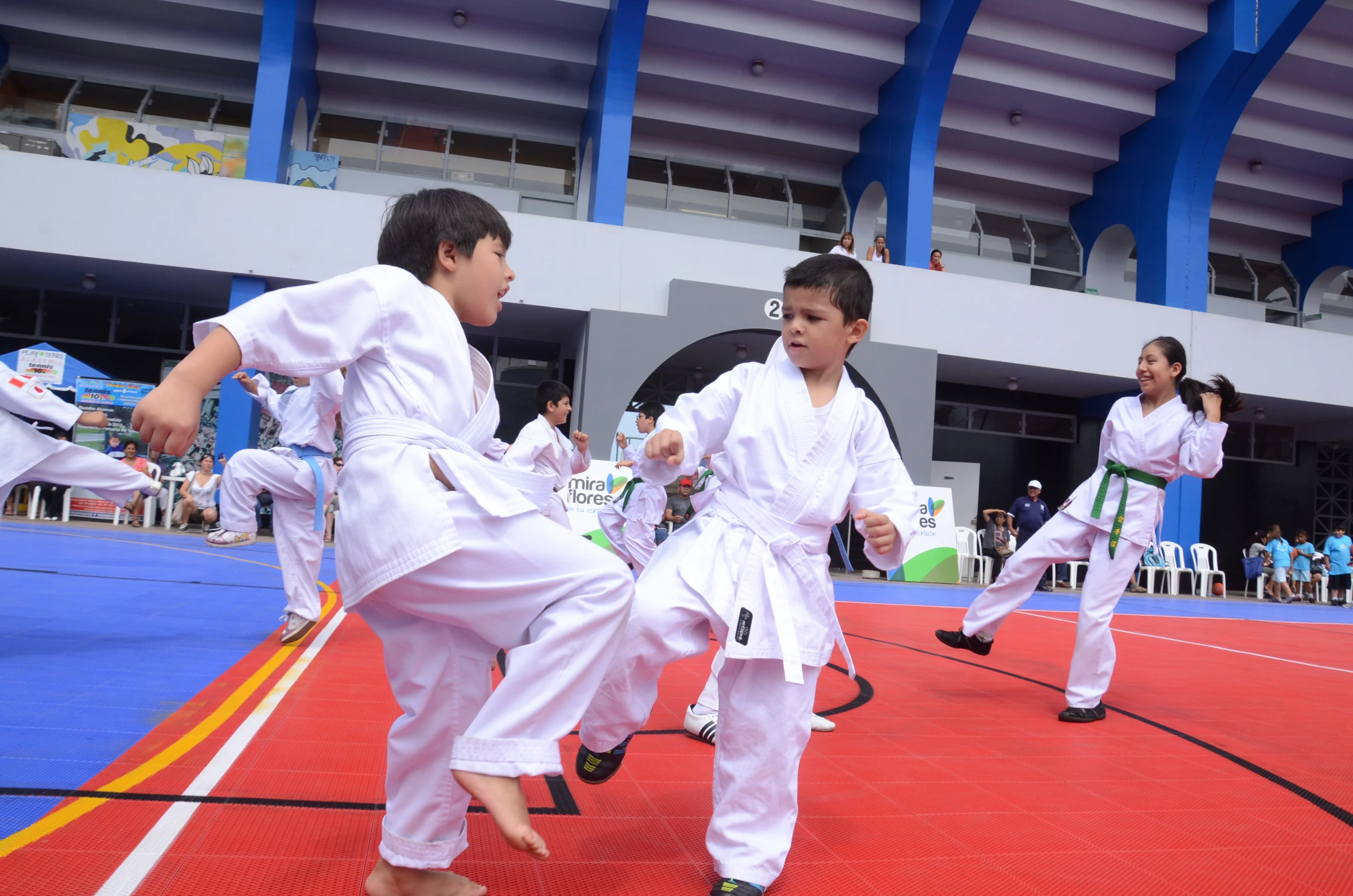 s with black belts standing in the ring at a karate tournament