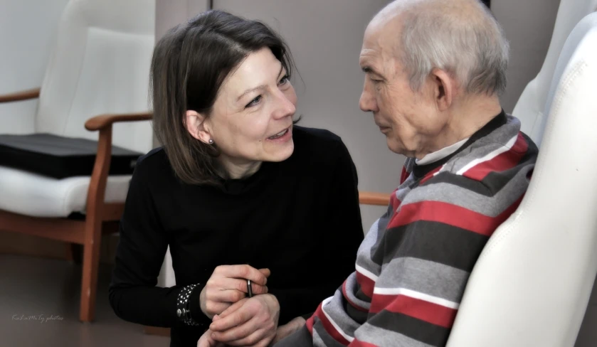 a woman smiling next to a seated man