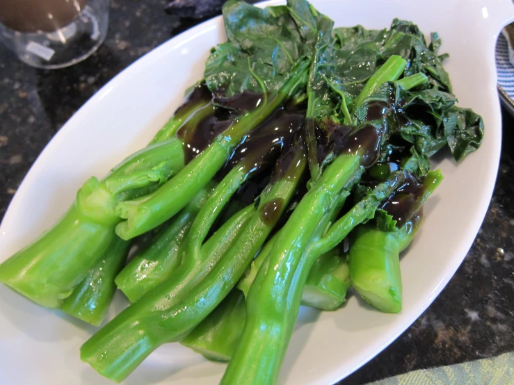 the green vegetables with sauce are on the plate