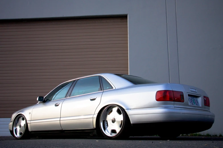 silver sedan parked outside a building with red door